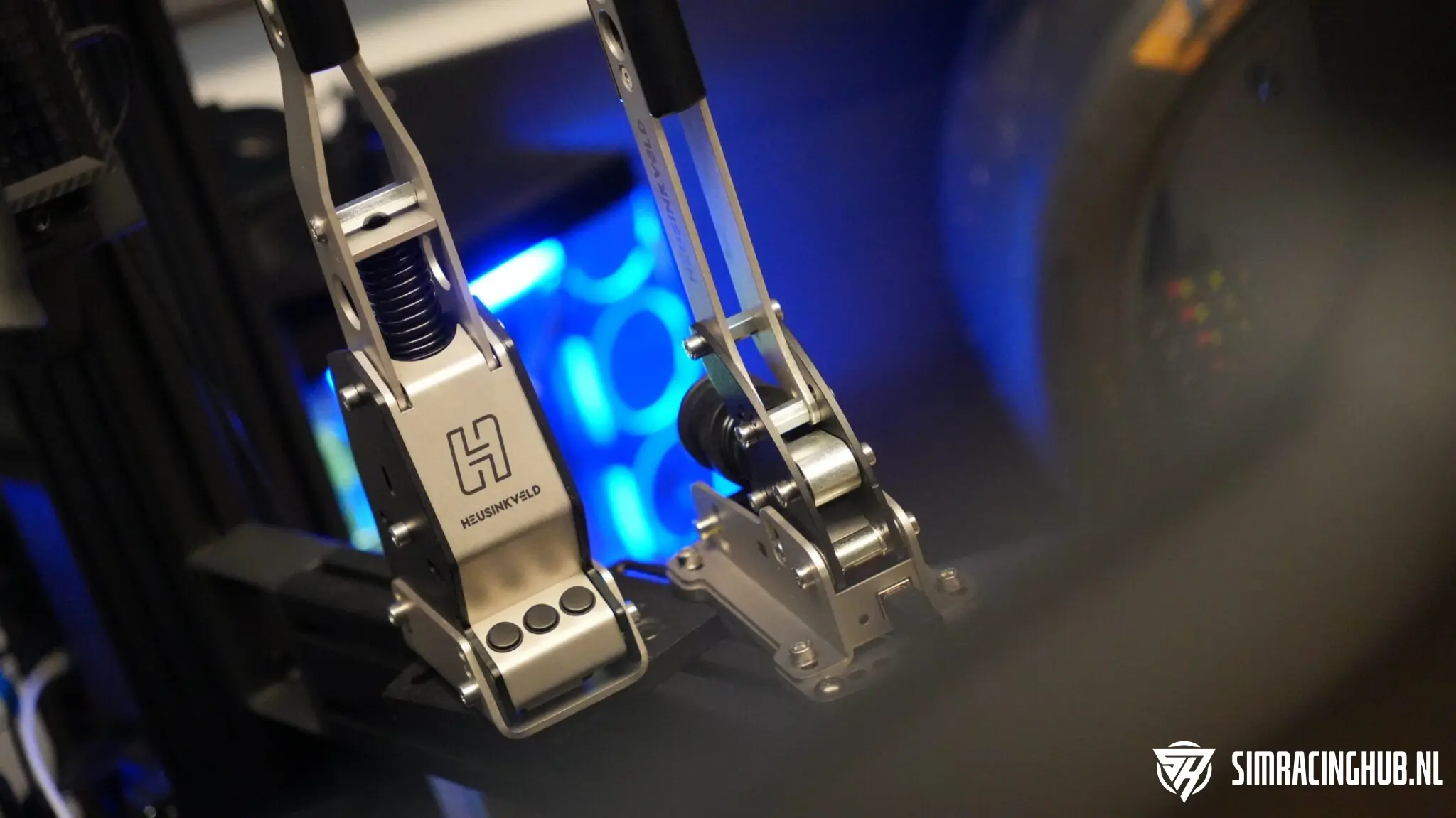 Heusinkveld MagShift and Handbrake V2 mounted side by side on a sim racing cockpit, with blue PC lighting in the background
